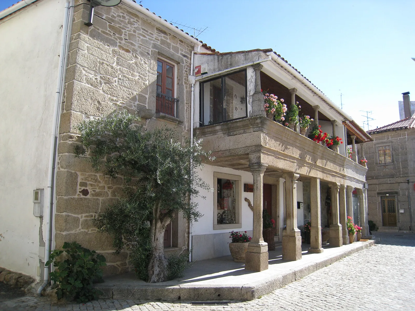 Casa com varanda de madeira sobre arcadas de granito em Sendim, Miranda do Douro