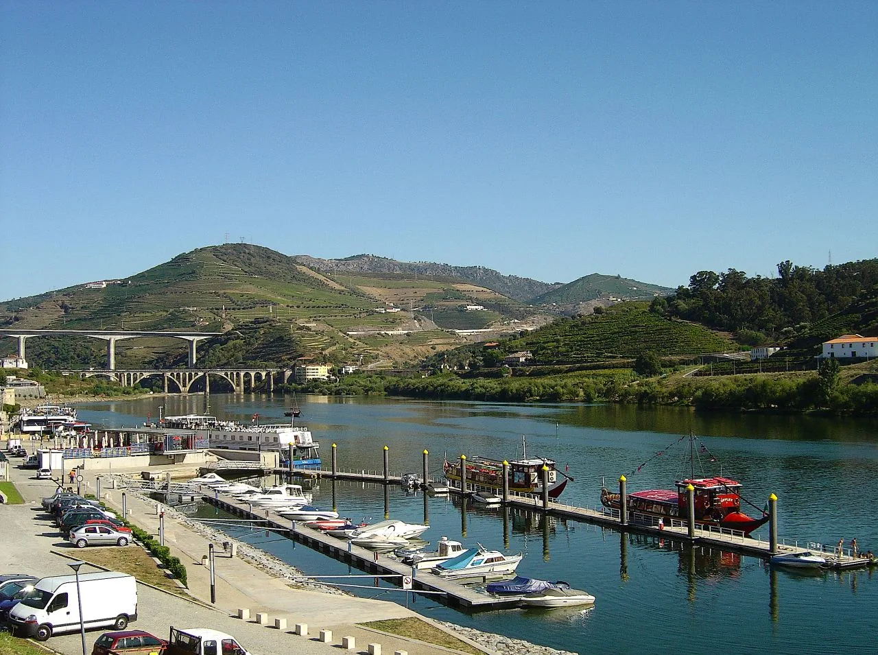 Embarcações atracadas junto ao cais da Régua, com socalcos de vinha ao fundo