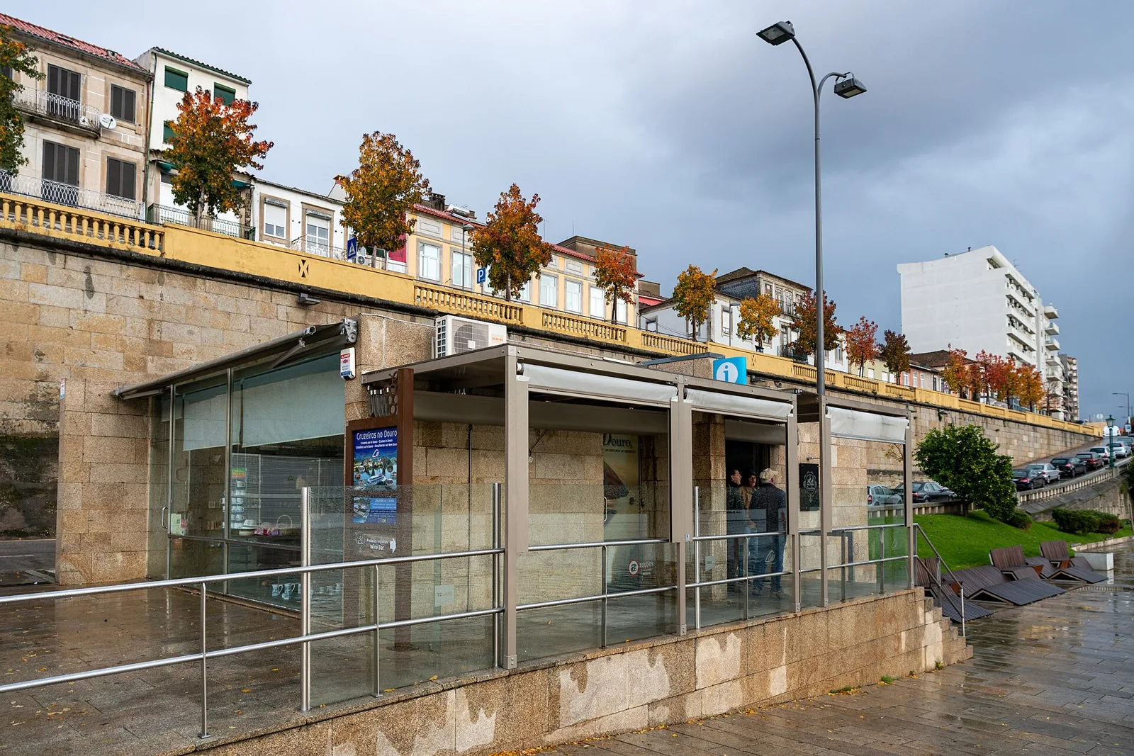 Edifício de apoio do cais da Régua, com balaustrada e árvores no topo do muro