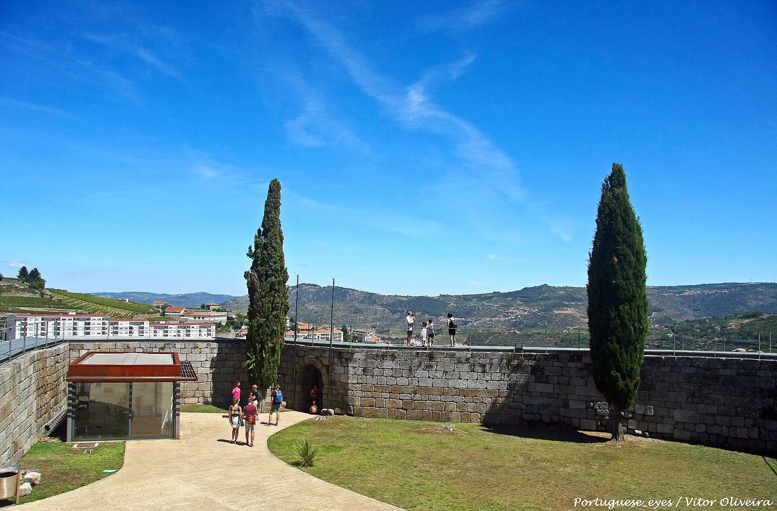 The castle courtyard with cypresses and a view over the valley