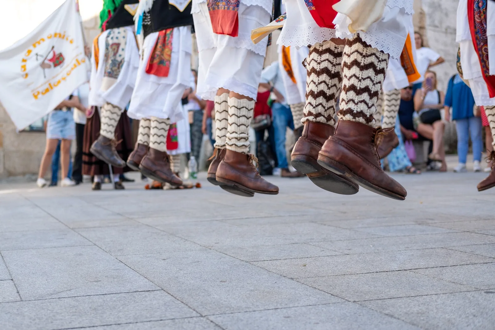 Pormenor das botas e das meias de lã de pauliteiros em pleno salto de dança