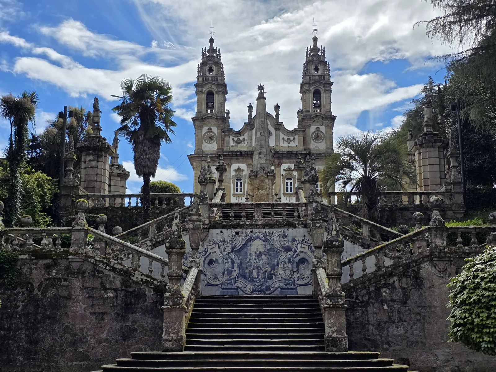 Escadaria barroca do Santuário com o patamar de azulejos, entre a vegetação